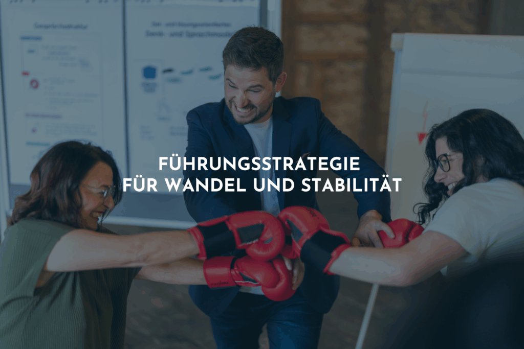 Zwei Frauen halten mit einem Lächeln im Gesicht die Fäuste hoch. Sie tragen rote Boxhandschuhe. Ein Mann greift ein und versucht den Kampf zu beenden.